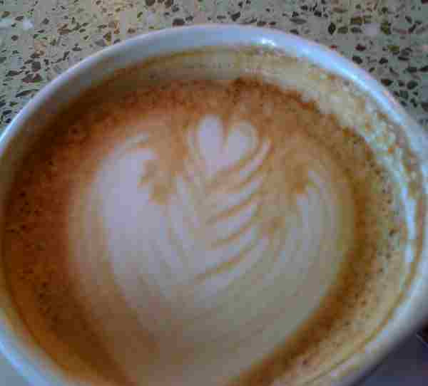 Latte in a white cup with a heart in the foam