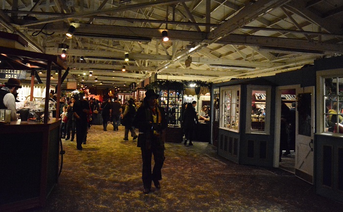 Visitors, some in Victorian costume, stroll the main concourse of shops at Dickens Fair
