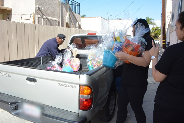 Volunteers load complted Easter bakets into flatbed of a pickup truck to be distributed to underprivleged youth