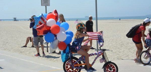 Great American Kids" Bike Parade participant with a bunch of mylar balloons tied to her bicycle