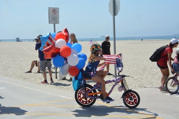 Great American Kids" Bike Parade participant with a bunch of mylar balloons tied to her bicycle