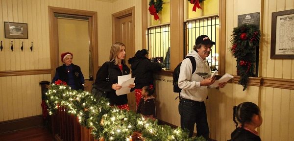 Passengers pick up tickets to THE POLAR EXPRESS™ at the station window.
