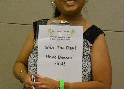 Tamiza Teja with "Eat Dessert First" sign