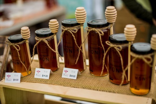 Honey jars with honey rippers on display.