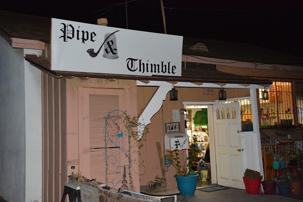Pipe & Thimble Bookstore glows with lights at night