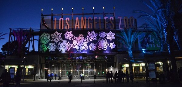 Entrance to Los Angeles Zoo lit up at night with snowflake decorations