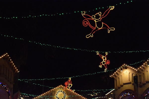 illuminated monkey silhouettes, outlined in neon, swing over the International Marketplace plaza