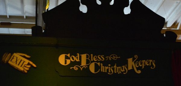 Green "God bless the Christmas Keeprs" sign with gold lettering
