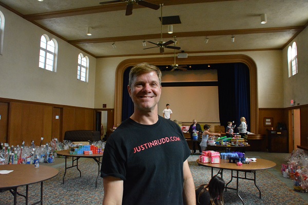 Justin Rudd smiles amid hall filled with Easter baskets