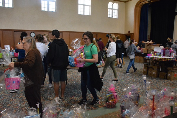 Volunteers pick up and ccarry baskets towards the door