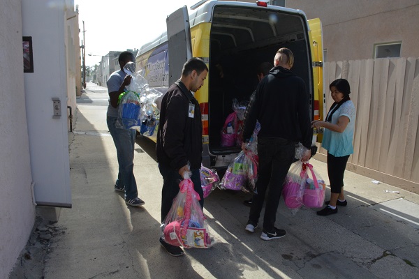 Volunteers carry completed Easter baskets to a Long Beach Rescue Mission truck