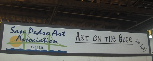 San Pedro Art Association, "Art on the Edge" banner, hangs from brown wooden rafters