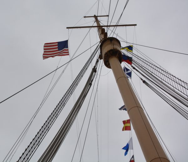 American flag waves from a ship's mast