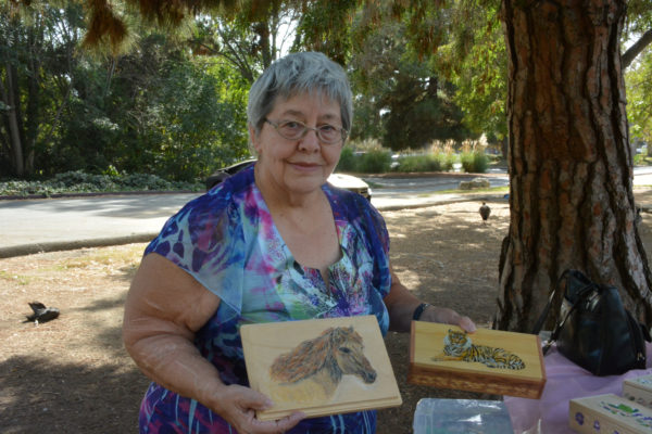 Liz Stark displays two of her woodcrafted boxes in El Dorado Park