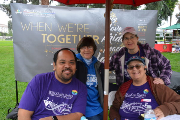 Four singers from West Coast Singers group smile at their exhibit table duirng SGV Pride 2018