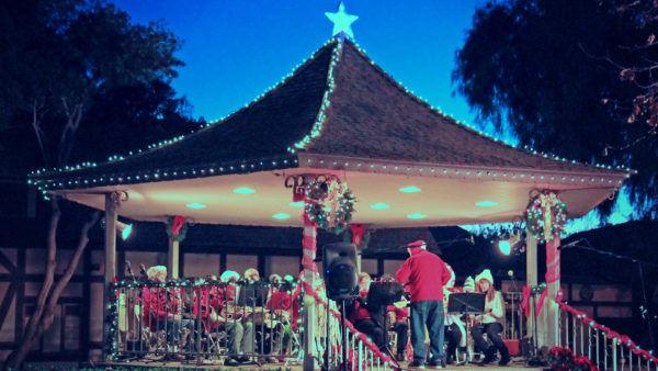 Band led by Santa plays in a star-topped gazebo decorated with Christmas lights and wreaths