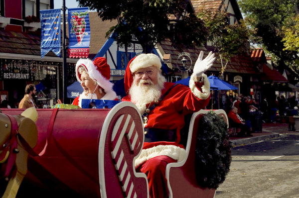 Santa waves from a "sleigh" as he and Mrs. Claus ride in the Julefest parade