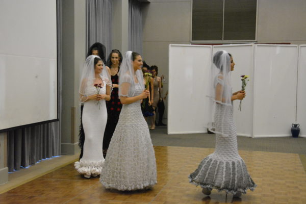 Procession of models in crocheted wedding dresses in gray, black and white during Yes4Arts fashion show
