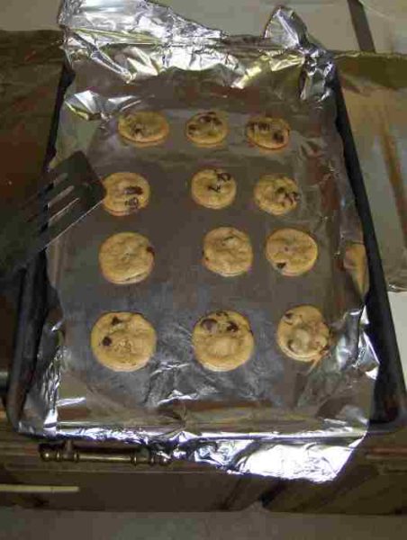 tollhouse cookies on foil-covered sheet with spatula