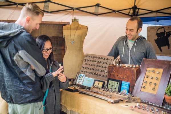 Couple look at jewelry made of antique keys during Pasadena Jackalope Fair