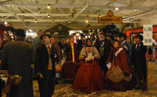 Singers in Victorian costume serenade Dickens Fair visitors while holding a "Gin is Sin" sign