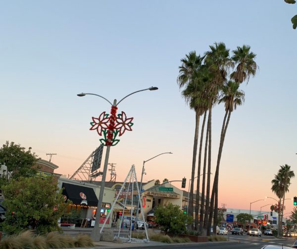 December sunset over Second Street with palm trees, poinsettia tinsel decorations on the lamppost and "Christmas tree" made of lights in the center median