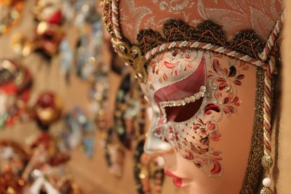 Venetian Carnevale-style mask with blurred festive lights in the background