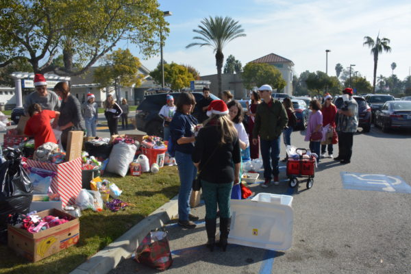 Volunteers in Santa hats sort boxes and bags of pet supplies outside Long Beach's Animal Care Services shelter