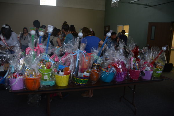 Volunteers byone a table filled with completed Easter baskets