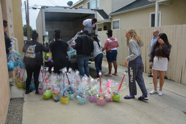 Volunteers load baskets onto truck in alley
