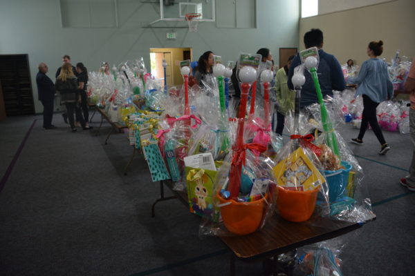 Volunteers carry Easter baskets as Operation Easter Basket winds down. Finished baskets sit on a table in readiness