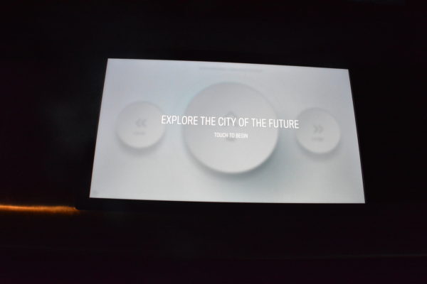 Interactive screen shows three white discs with the words "City of the Future" over them