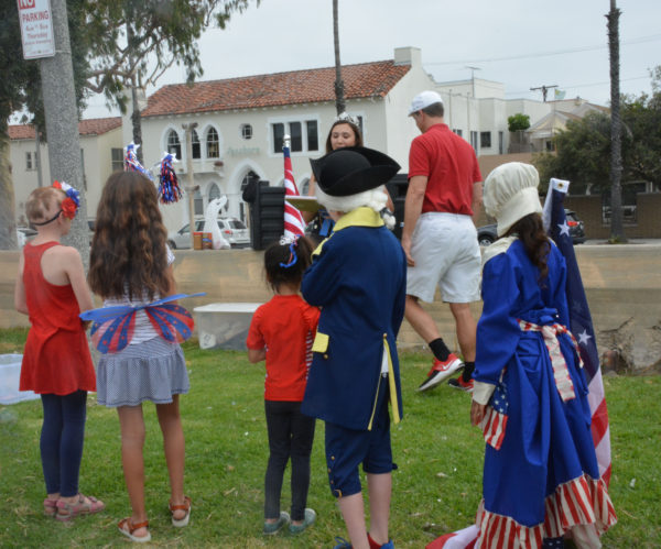 children dressed in colonial costumes listen as parade oranizer Justin Rudd prepared to announce costume contest winners