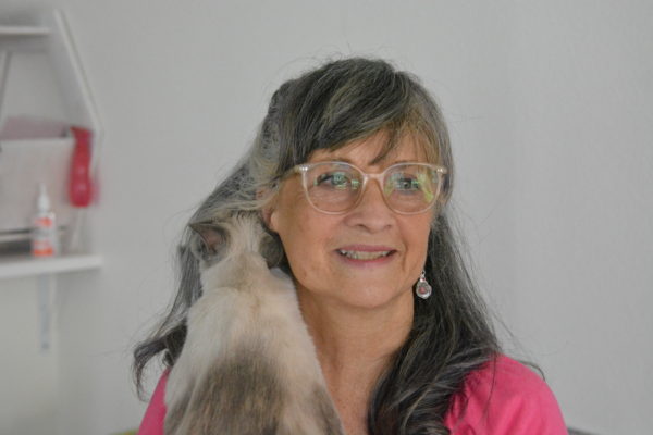 Feline Good owner Pam Leslie hugs a cat which nuzzles into her shoulder