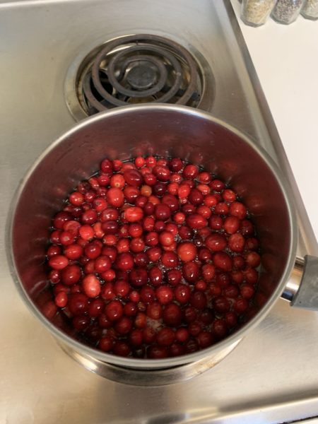 Red cranberries in a silver pot on the stove
