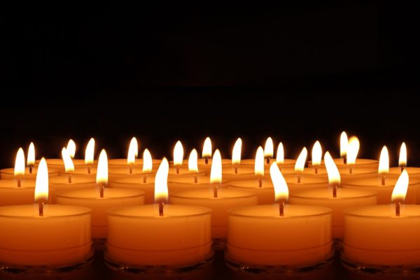 numerous small gold tealight candles glow in the dark