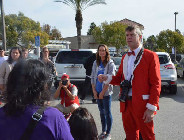 Community activist Justin Rudd, in red Santa suit with a red bow tie, stands with Operation Santa Paws volunteers
