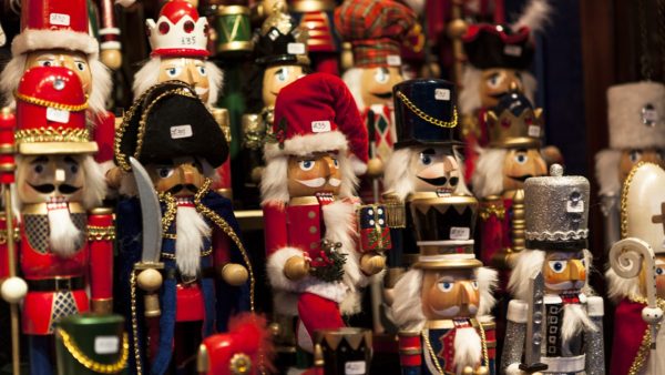 Rows of handcrafted wooden nutcrackers with nutcracker with Santa hat in the center