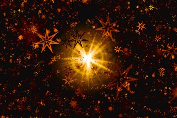 Snowflakes and stars projected in light swirl against a dark background