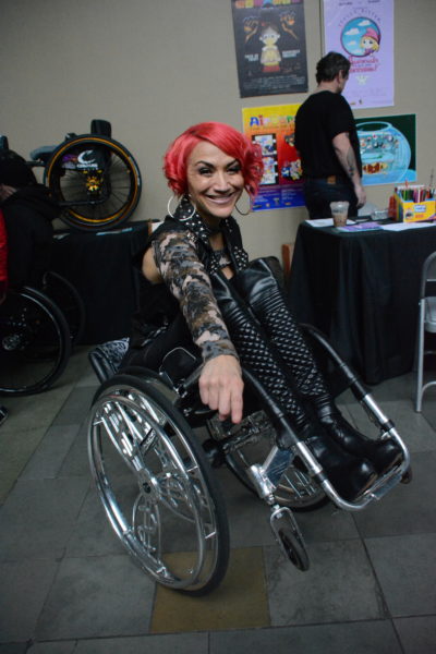 Auti Angel smiles and pops a wheelie near the Colours booth
