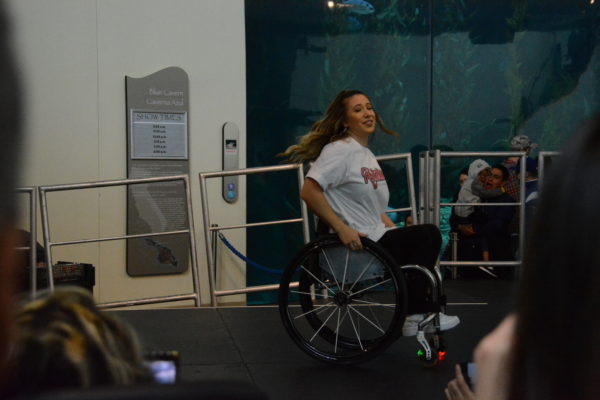Rollettes founder Chelsie Hill lights up her wheels while doing a dance move in her wheelchair onstage