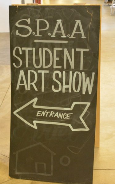 Blackboard sign, "SPAA Student Art Show", with a white chalk arrow