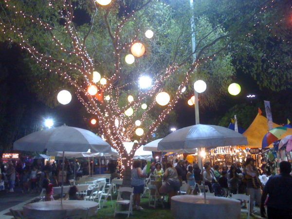 OC Fair main area at night with umbrella tables and lights