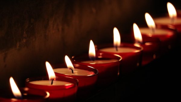 Lit red tea light votive candles in a row