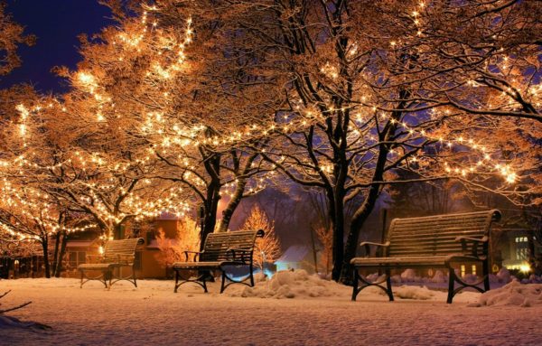 Gold Christmas lights illuminate a snowy street