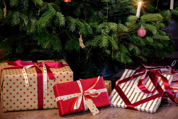 Three packages in red-and-white paper under a Christmas tree