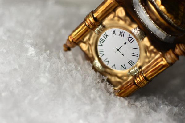 Ornate gold clock ornament on a bed of sparkly "snow"