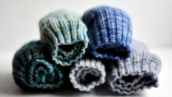 Piles of rolled-up blues and gray woolen socks