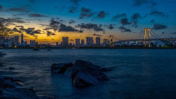 Night shot of Tokyo with sunset over the skyline and ocean in the forefront