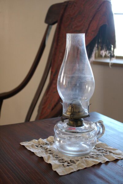 Kerosene lamp on a lace doily near a window